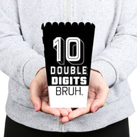 Person holding a black and white popcorn box with '10 Double Digits Bruh.' text.