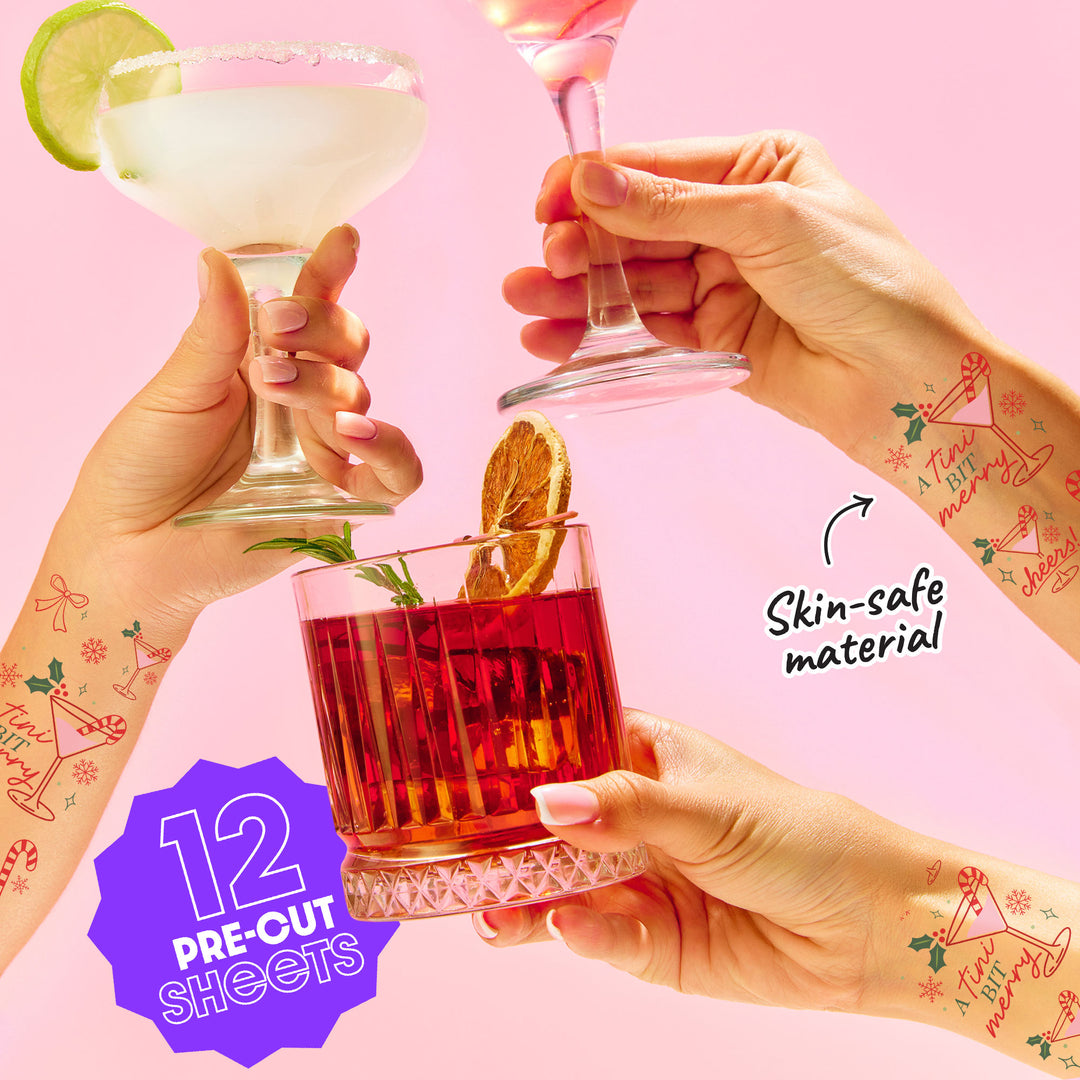 Three hands holding cocktails with temporary tattoos on a pink background, featuring 'Skin-safe material' text and '12 Pre-cut Sheets' label.