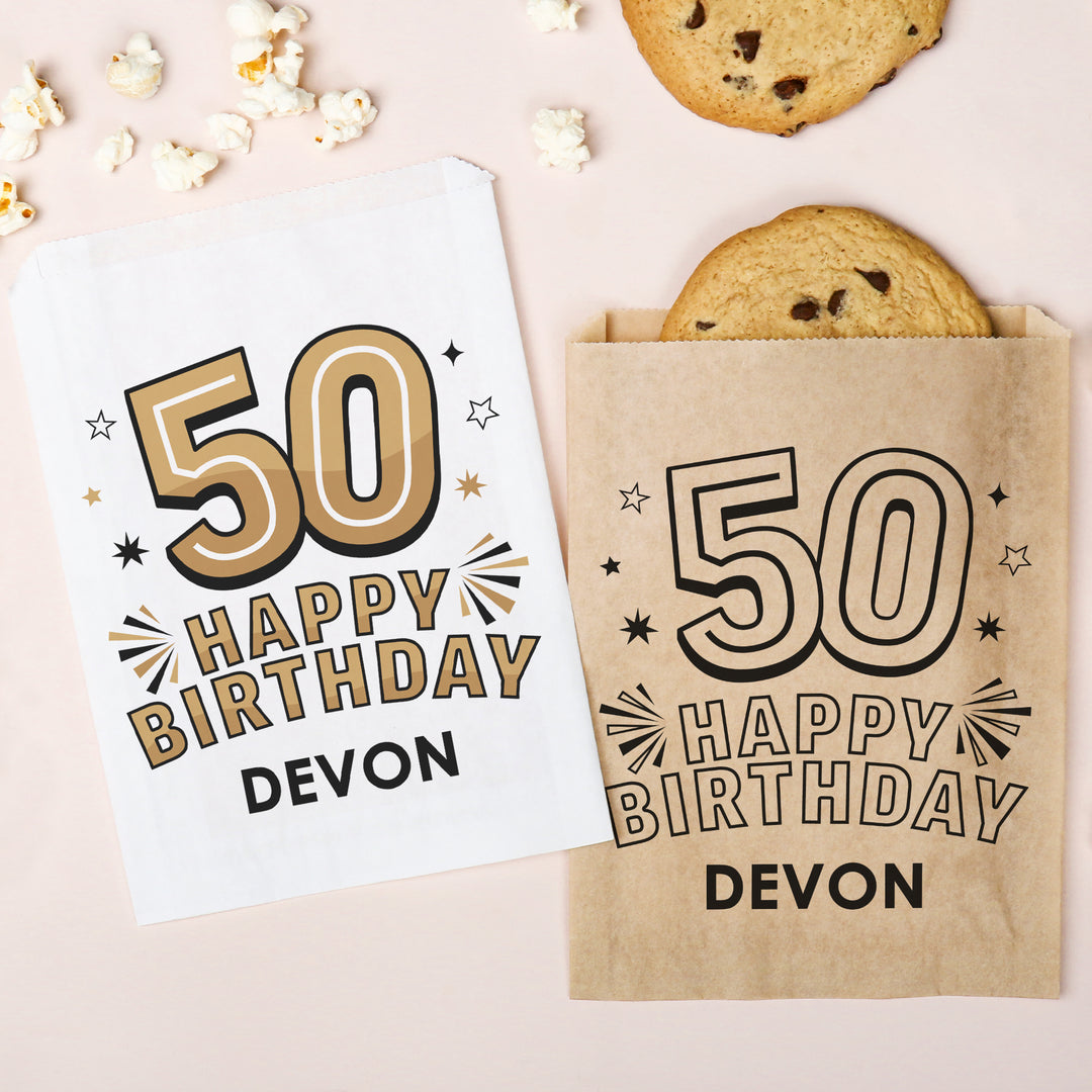 Custom Birthday paper bag with '50 Happy Birthday Devon' text on a light pink background with cookies and popcorn.