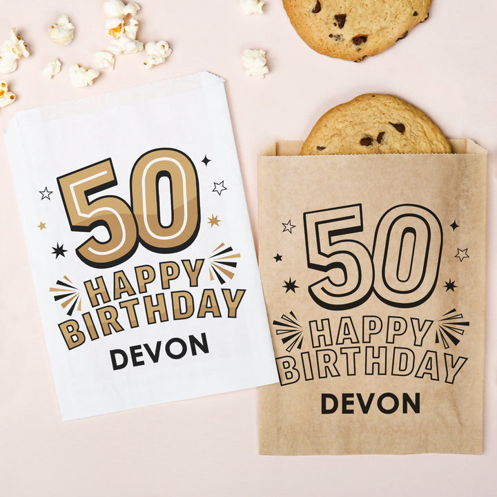 Custom Birthday paper bag with '50 Happy Birthday Devon' text on a light pink background with cookies and popcorn.