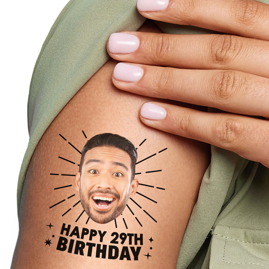 A close-up image of a person's arm with a custom temporary tattoo that features a photo with custom text 'HAPPY 29TH BIRTHDAY'.