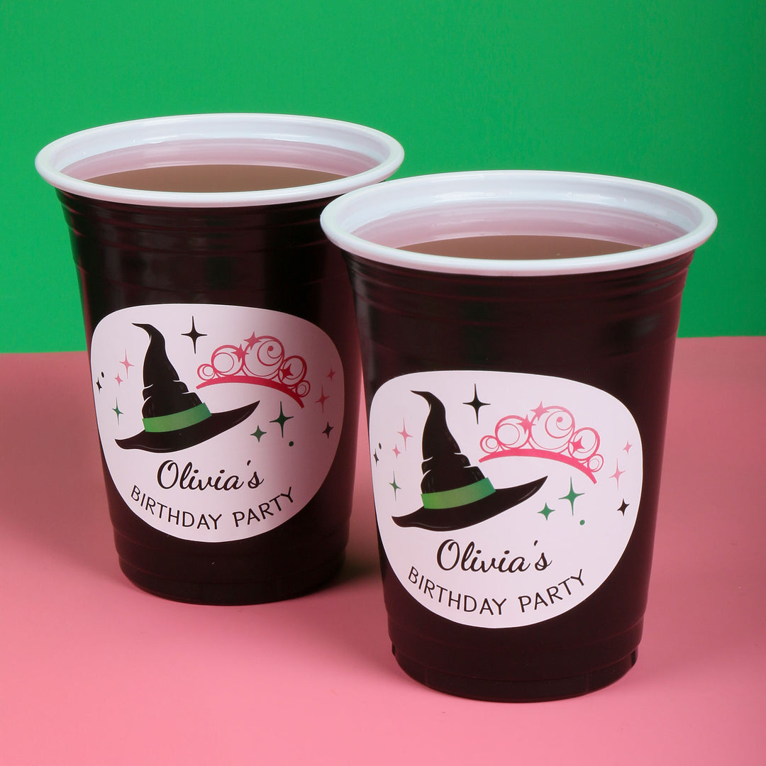 Two custom party cups with 'Olivia's Birthday Party' labels on a pink and green background.