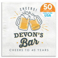 A custom text napkin with 'CHEERS! Devon's Bar CHEERS TO 40 YEARS' printed on it, featuring two clinking beer mugs.