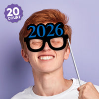 Person wearing novelty glasses with '2026' text against a purple background