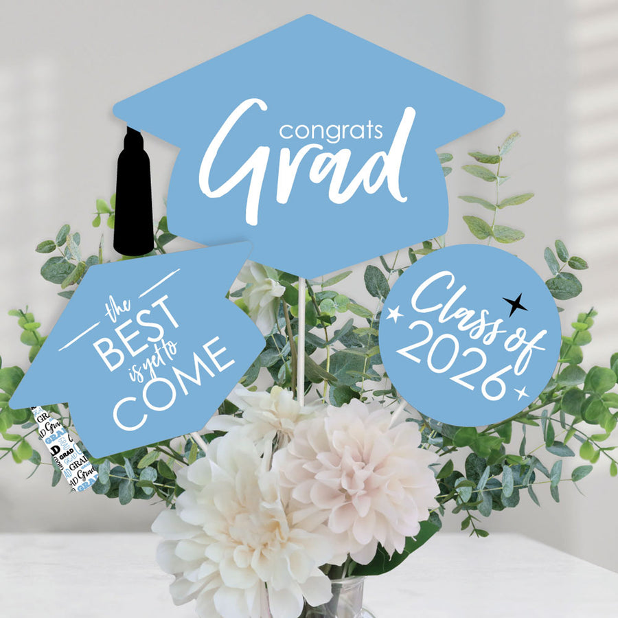 Graduation-themed decorations with 'Congrats Grad', 'The Best is yet to come', and 'Class of 2026' text on a blue background with flowers.