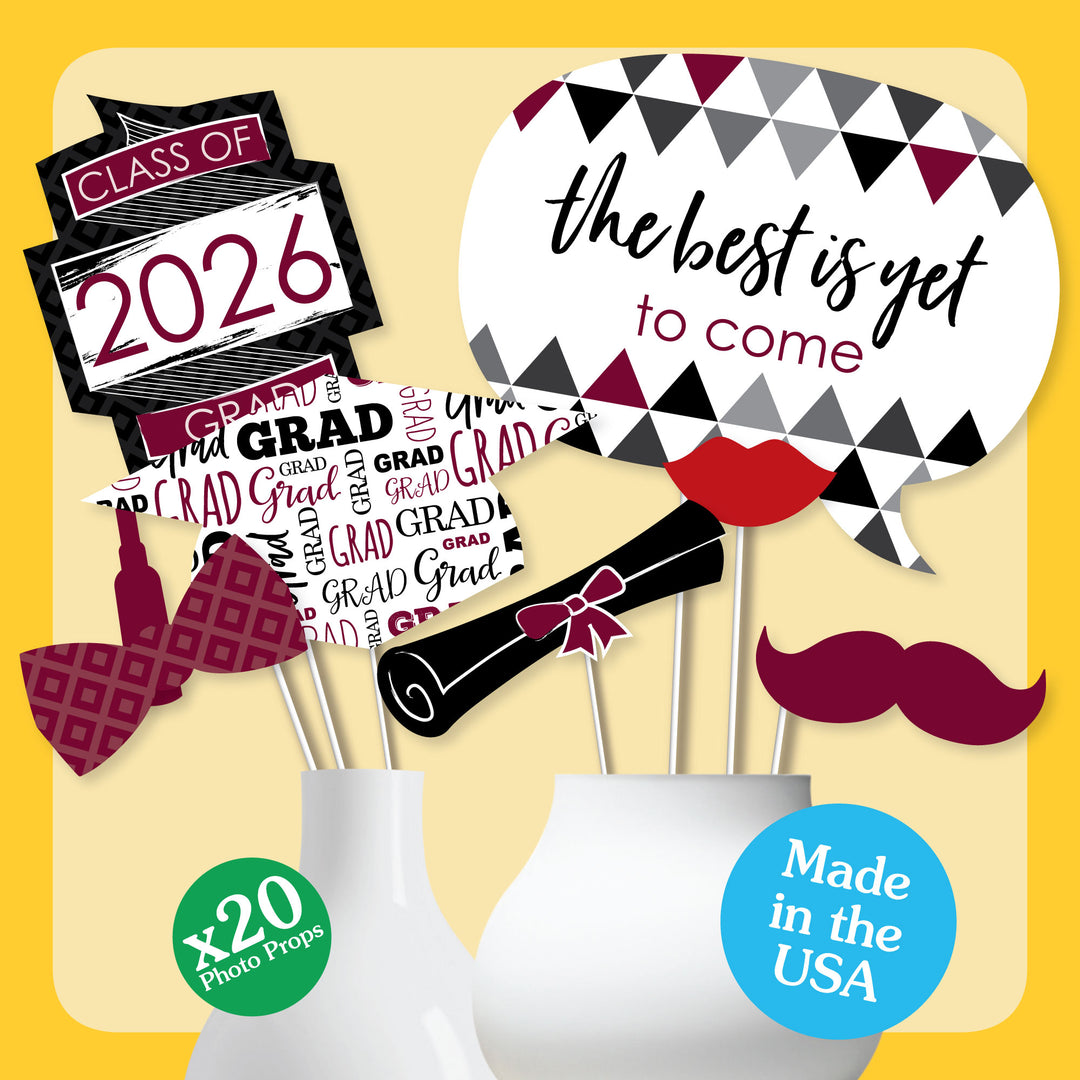 Graduation-themed photo props with 'Class of 2026' and 'The best is yet to come' signs on a yellow background.