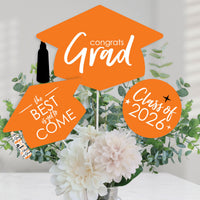 Graduation-themed decorations with 'Congrats Grad' and 'Class of 2026' on an orange background.