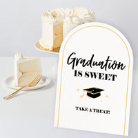 Black and gold grad party table sign design close-up for dessert and drink tables