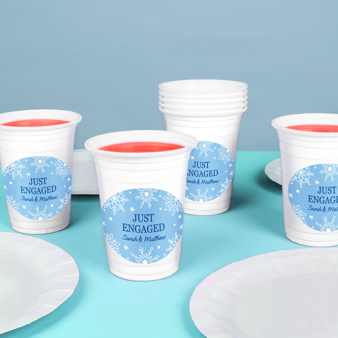 White paper cups with 'Just Engaged' labels on a blue background