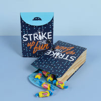Party favor bag with 'Strike up the Fun' text on a blue background
