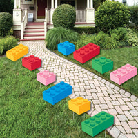 Large Colorful toy building blocks yard signs arranged on a lawn in front of a house.