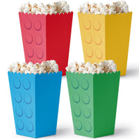 Four colorful popcorn buckets with a block design filled with popcorn on a white background.