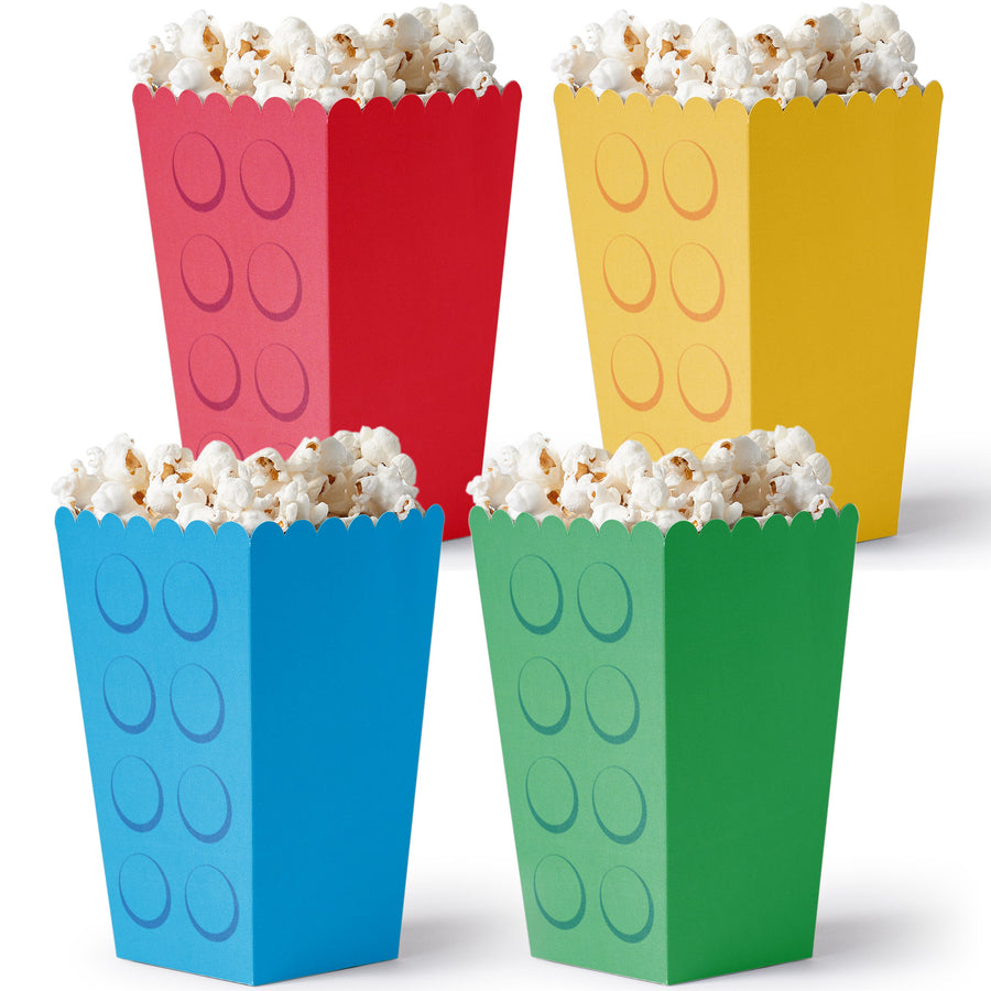 Four colorful popcorn buckets with a block design filled with popcorn on a white background.