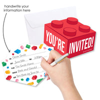Red LEGO-style invitation card with 'You're Invited!' text, hand holding a pen over a white card with colorful LEGO pieces, and an envelope.
