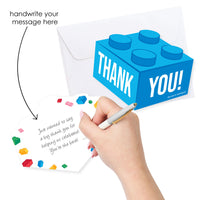 Blue LEGO-style block thank you card with 'THANK YOU!' text, hand holding a pen, and colorful gemstones on a white background.