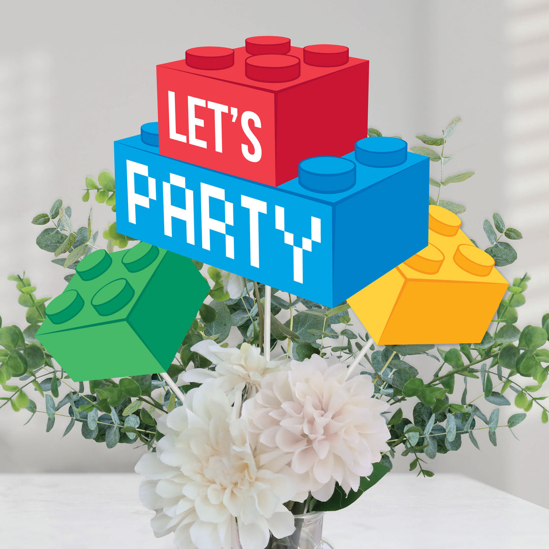 Colorful Lego-style 'Let's Party' sign with flowers and greenery on a light background
