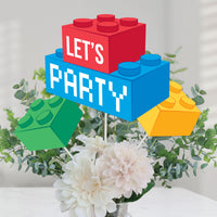 Colorful Lego-style 'Let's Party' sign with flowers and greenery on a light background