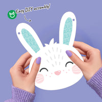 Hands holding a bunny face banner pennant with 'bd' logo and text on a purple background