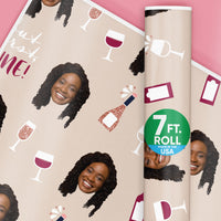 Wine-themed wrapping paper with a woman's face and wine glasses on a pink background.