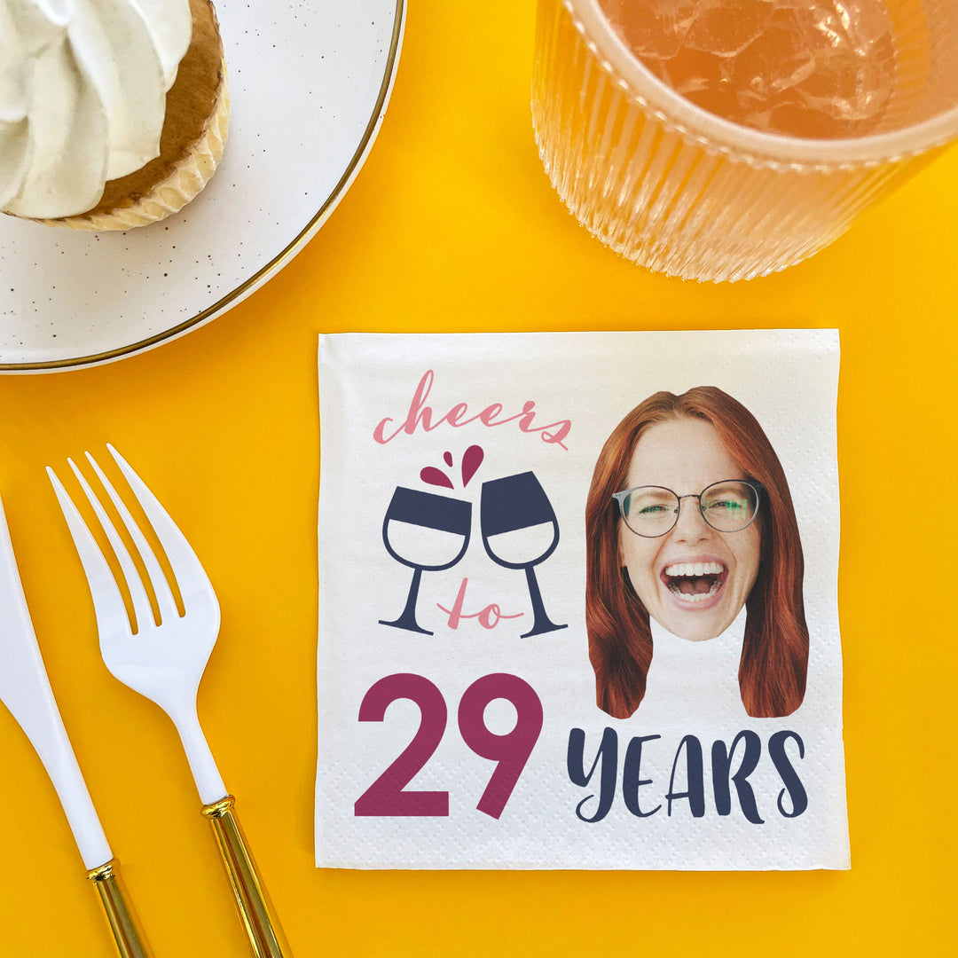 Custom Napkin with a printed design of two wine glasses, a heart, and text on a yellow background with cutlery and a dessert.
