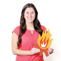 Woman holding a cutout of a camp fire design on a white background