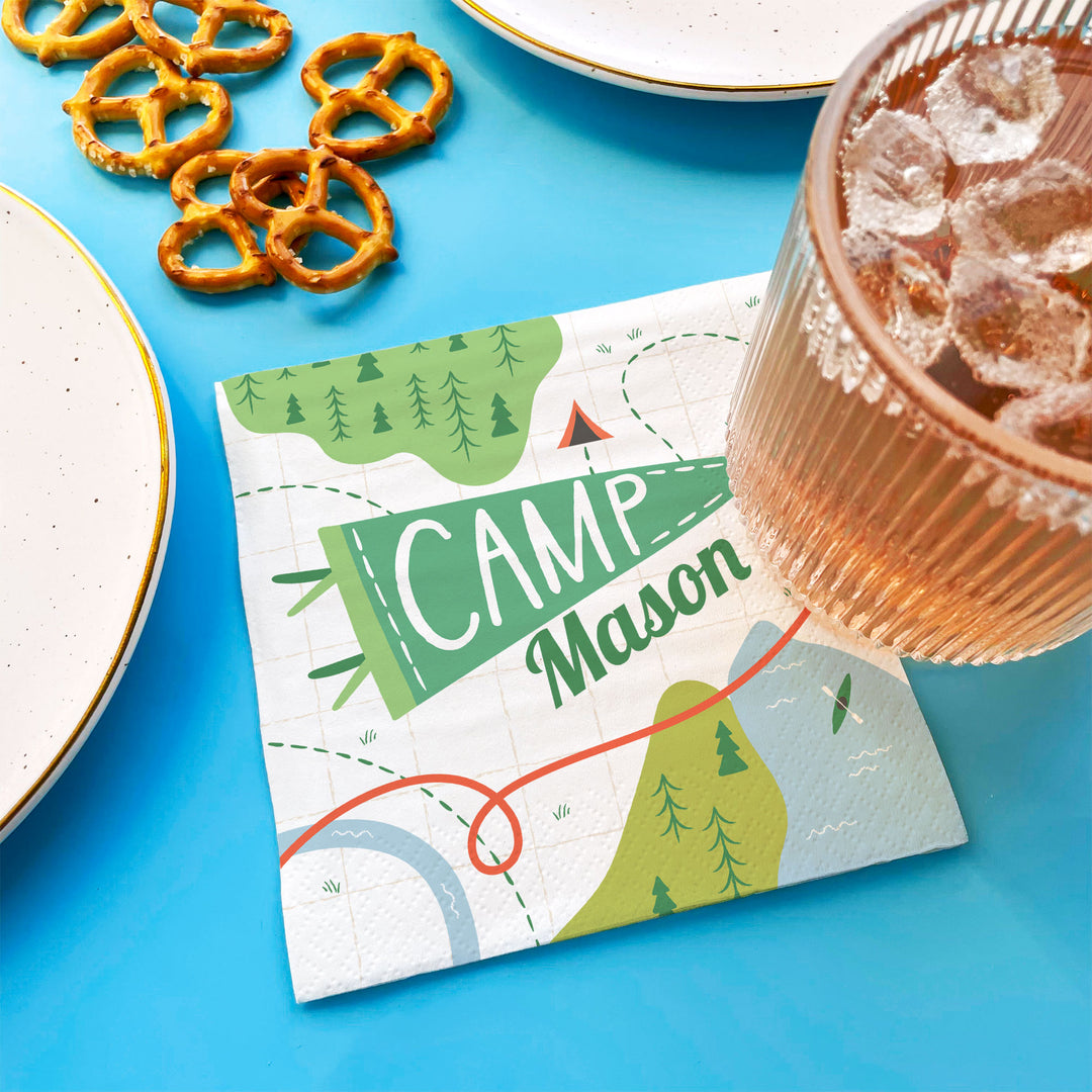 Camping birthday party table setup with custom napkins
