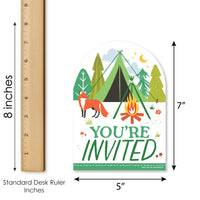 Invitation card with camping design, fox, and campfire next to a ruler for size reference.