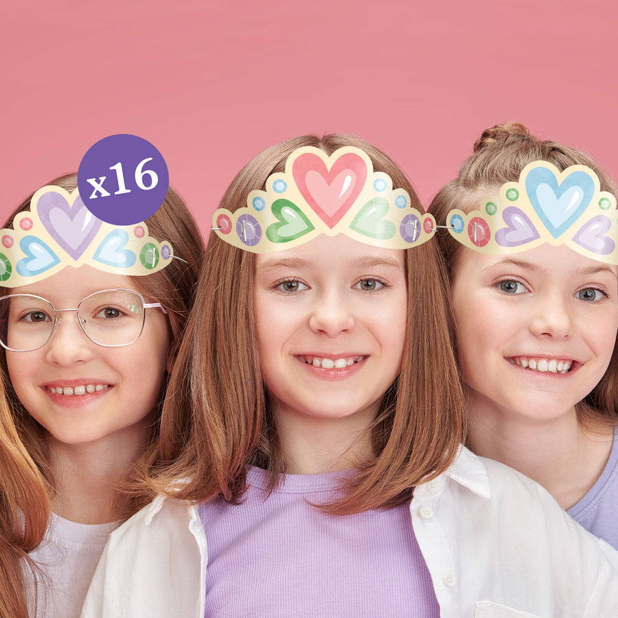 Three girls smiling and wearing colorful paper crown headbands with heart designs.