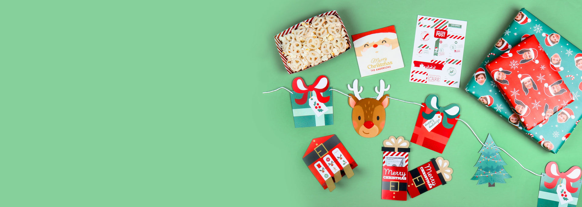 Collection of Christmas-themed items including gift bags, a reindeer figurine, and decorative cards on a green surface.