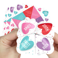 A hand holding several colorful paper fortune tellers with heart shapes and text messages like 'I LOVE YOU', 'SWEET HEART', and 'U ROCK' written on them.