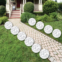A set of 10 groovy hippie party lawn decorations arranged on a garden path, resembling disco balls with a white and silver geometric pattern.