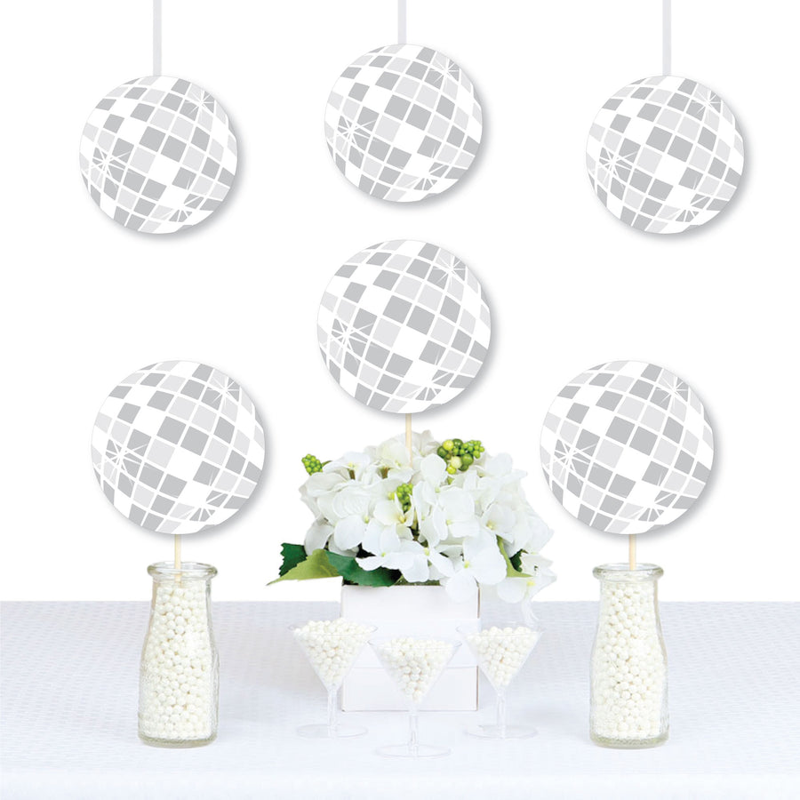 A set of white disco ball-shaped decorations with a geometric pattern, displayed as cutouts on sticks, used for party decorations.