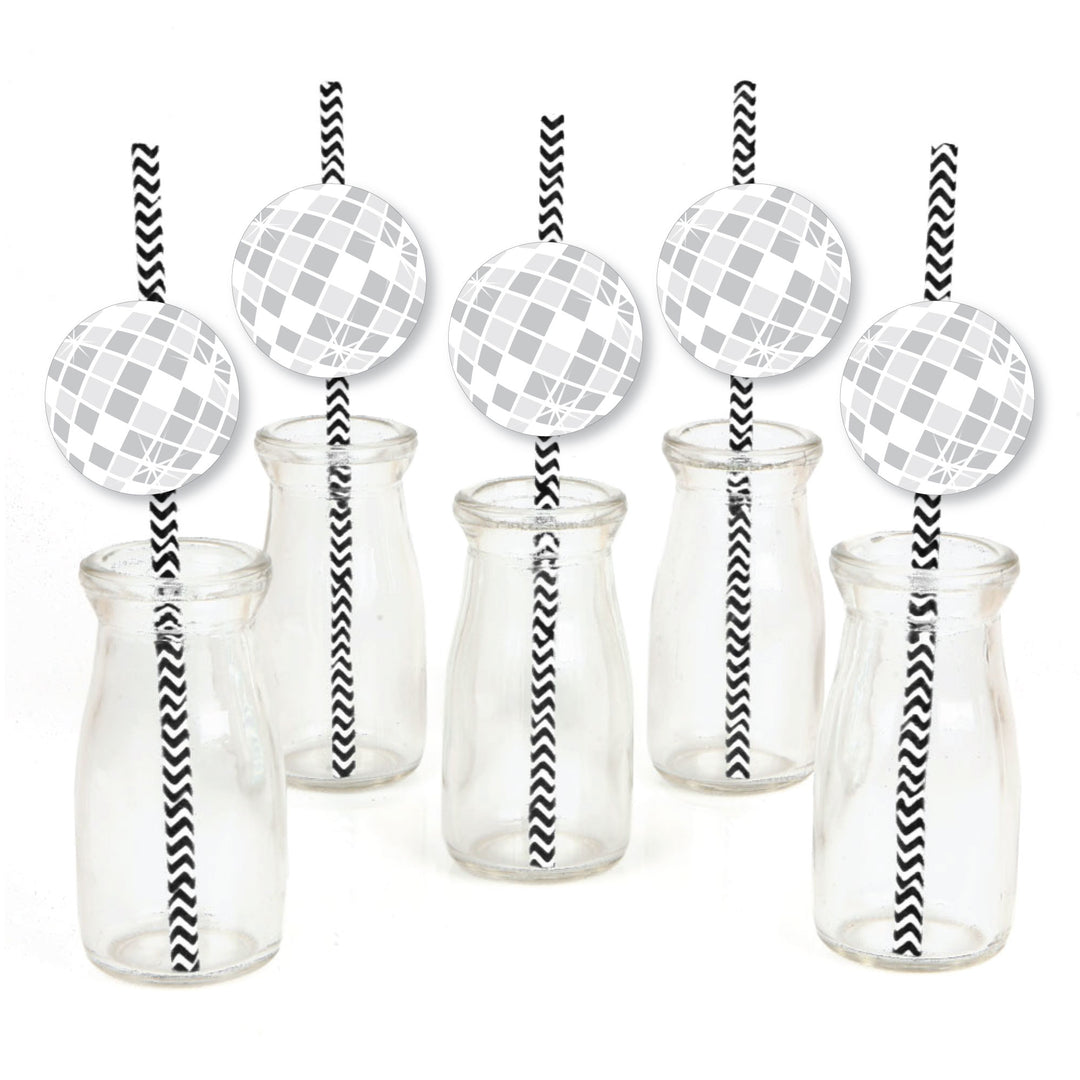 A set of paper straw decorations with striped patterns and disco ball shapes on them, displayed alongside clear glass bottles and jars.