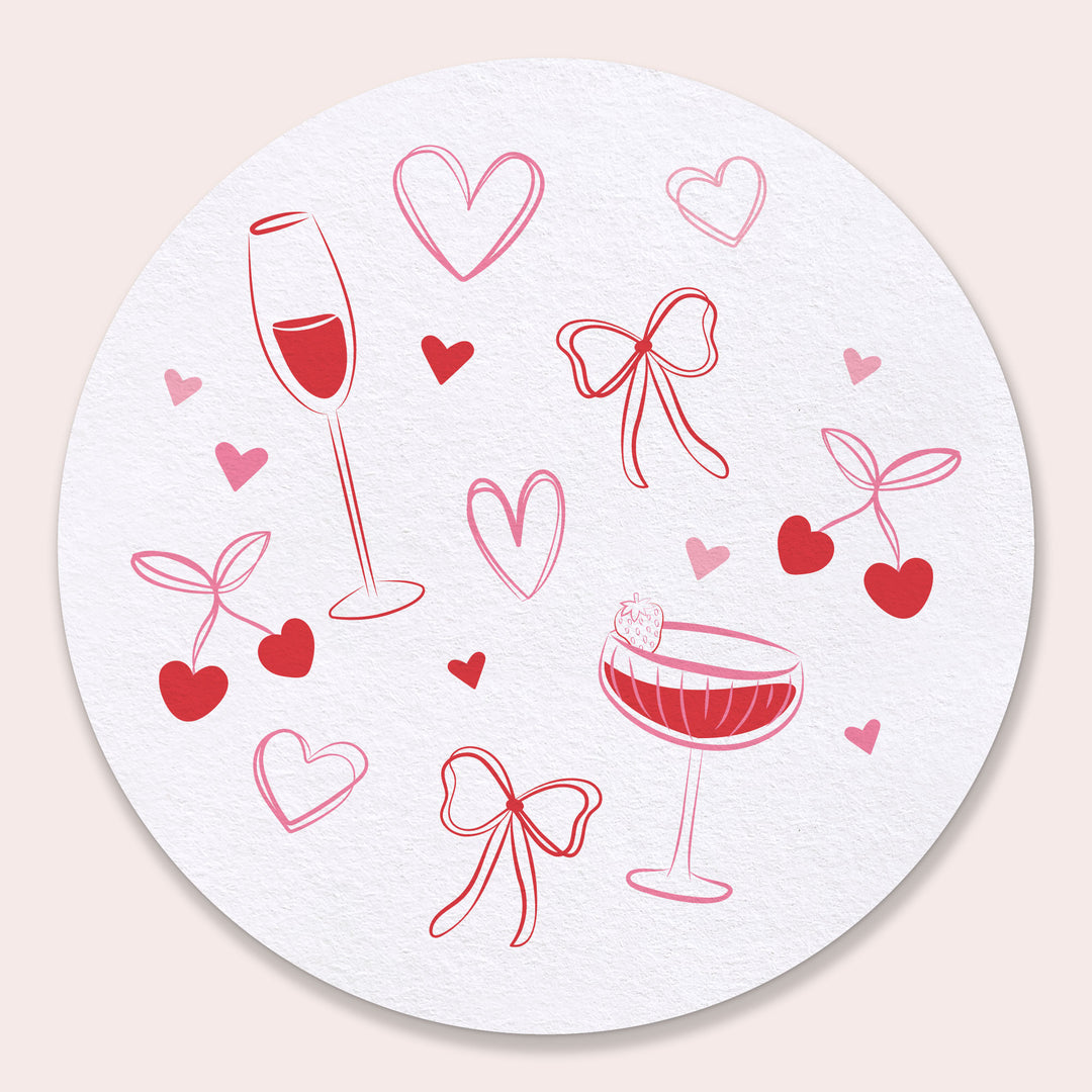 Round coaster with red wine glasses, hearts, and bows on a white background