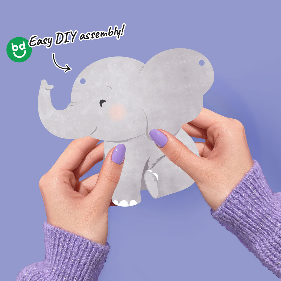 Hands holding a paper elephant cutout for a garland banner with 'Easy DIY assembly!' text and BD logo on a purple background