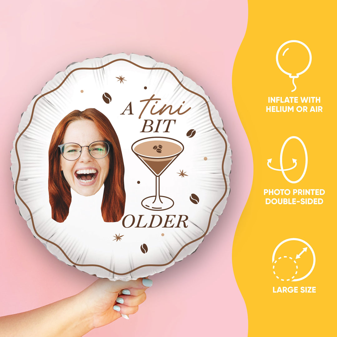 Balloon with a printed design of a woman's face, a cocktail, and text on a pink background.