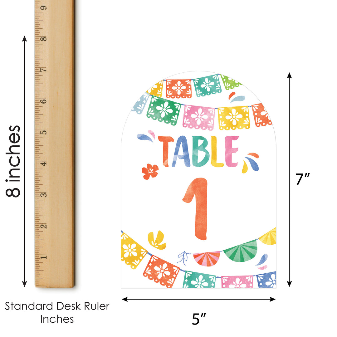 Colorful table number with decorative elements and a ruler for scale on a white background