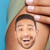 A close-up image of a person's arm with a temporary tattoo of a smiling face.