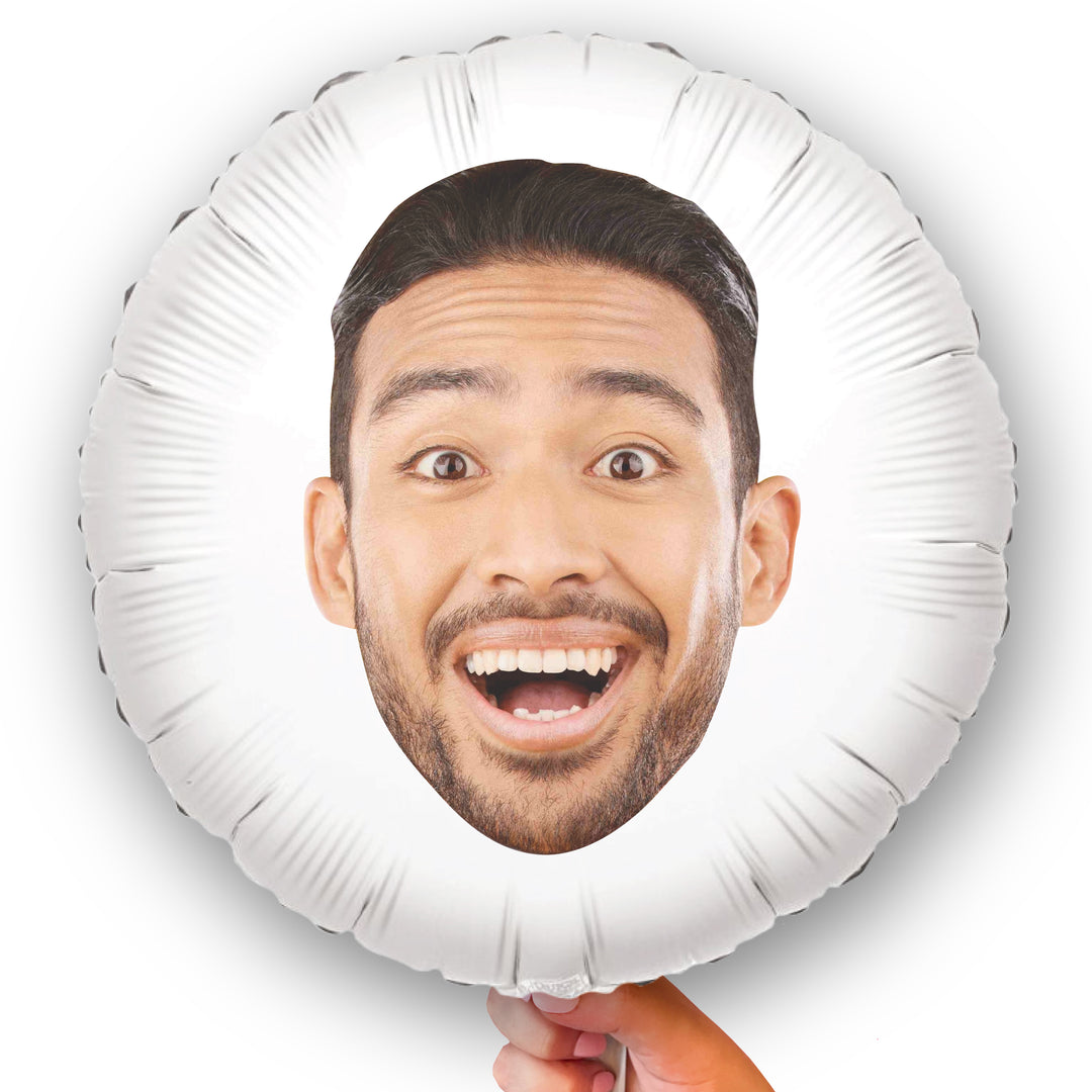 A custom round white balloon with a double-sided print of a person's face, held in a hand.