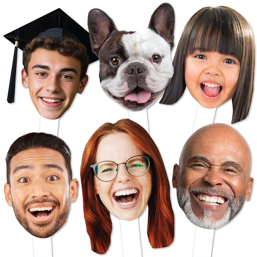 A collection of custom face cut-outs on sticks, featuring various smiling faces of people and a dog.