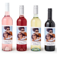 Four custom wine bottles stickers with custom photo labels featuring an image of a smiling person wearing sunglasses.