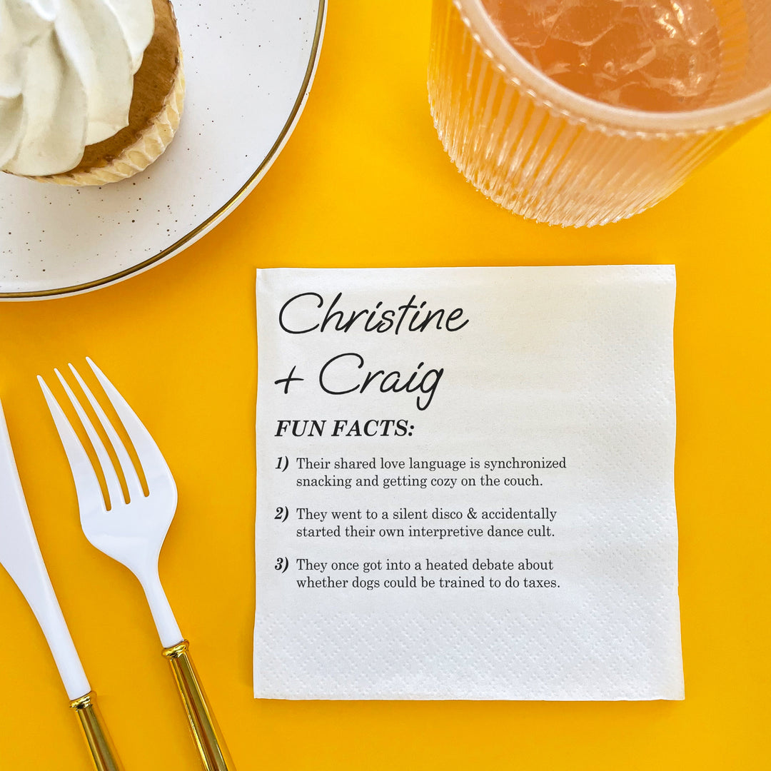 Napkin with fun facts about the wedding copuple on a yellow table with a dessert and drink.