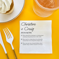 Napkin with fun facts about the wedding copuple on a yellow table with a dessert and drink.
