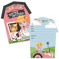 An invitation card with a custom photo of a girl with farm animals and a pink barnyard setting, including a space for a photo cut-out, accompanied by a white envelope with a farm-related design.