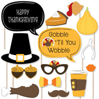 A collection of printed and cut Thanksgiving-themed photo booth props, including glasses, mustaches, bow ties, lips, hats, and other items with Thanksgiving-related designs.