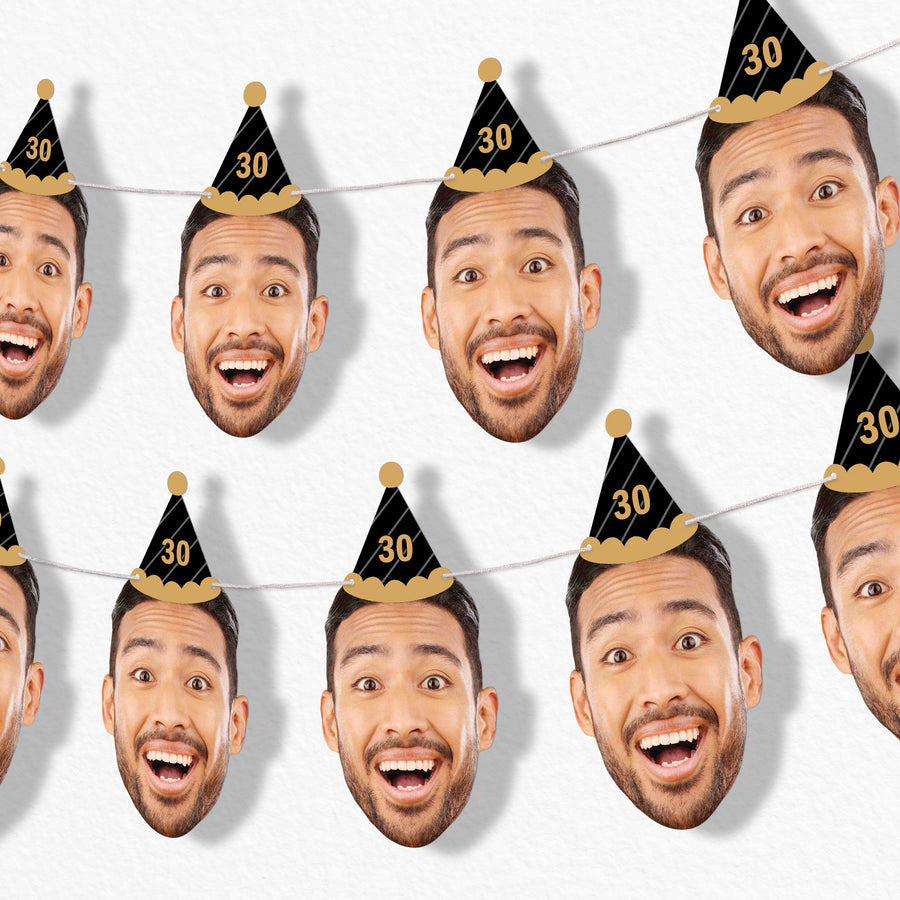 A series of oversized face cutouts with a man smiling, wearing a black and gold birthday hat with the number 30 on it, connected by white satin cording.