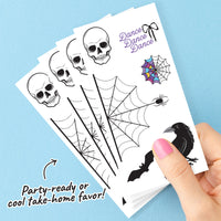 Halloween-themed temporary tattoos on a card with a hand holding the card against a blue background.