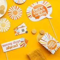 Decorative items with 'here comes the Son' and 'sunny days ahead' text on a yellow background.