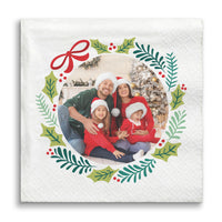 Napkin with a family photo surrounded by Christmas-themed decorations on a white background