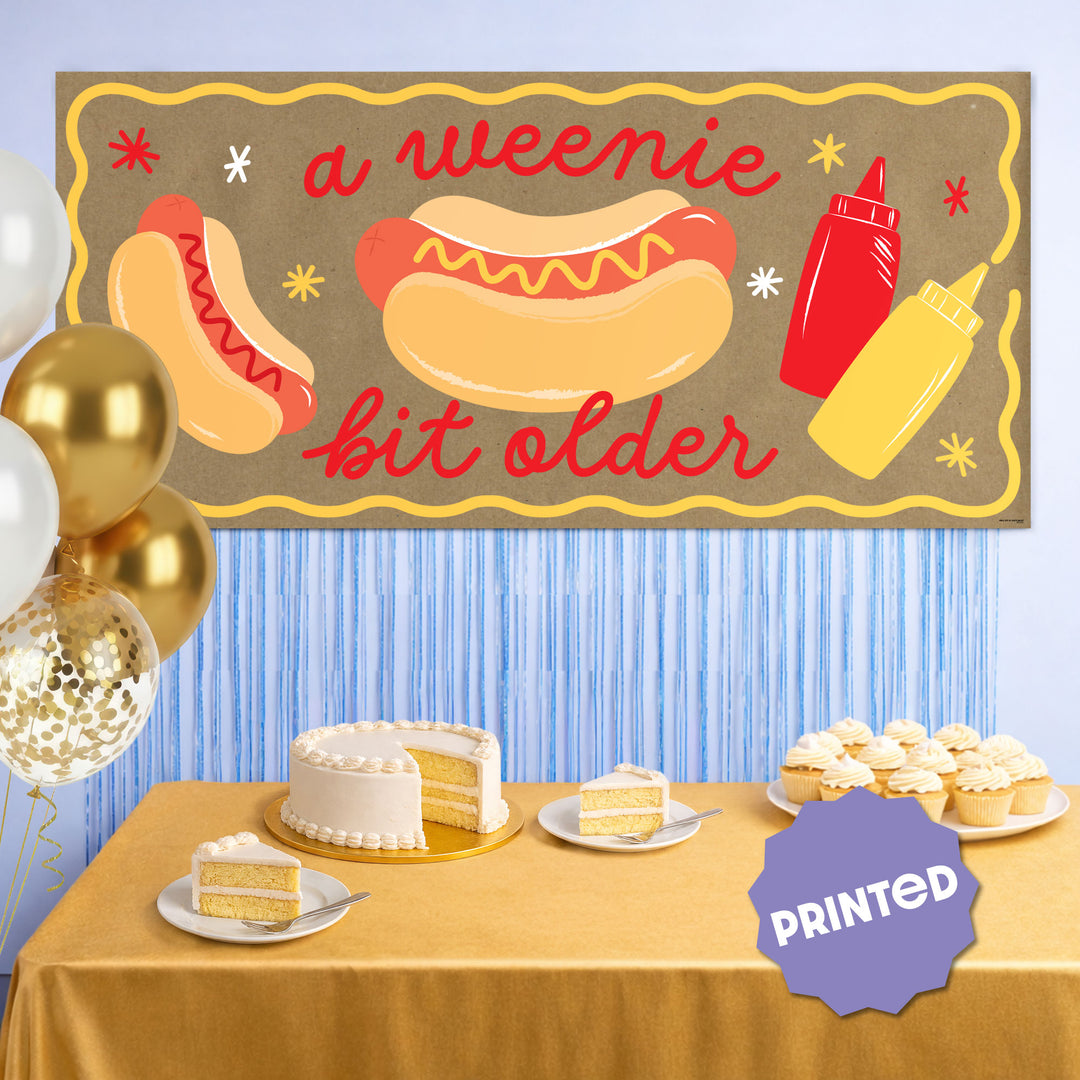 banner styled behind hot dog bar at party